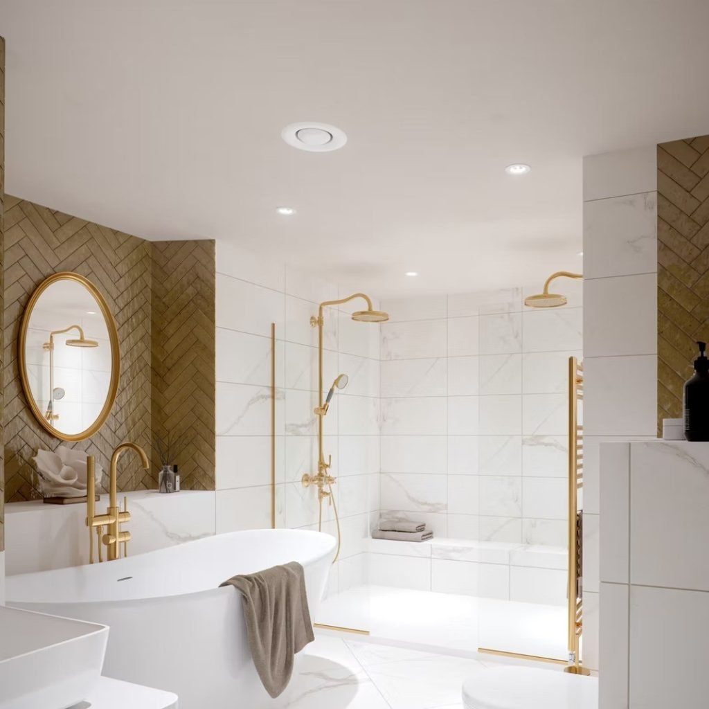 Spa-style bathroom with a freestanding tub, twin rainfall showers, marble tiling and brushed-gold fittings.