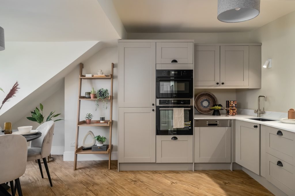 A contemporary kitchen and dining area staged by WildKind Interiors for a Grove Road Harrogate property. This space features light grey shaker-style cabinetry, integrated double ovens...
