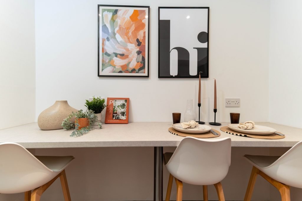 Communal dining space with a breakfast counter, sculptural vases and bold graphic prints.