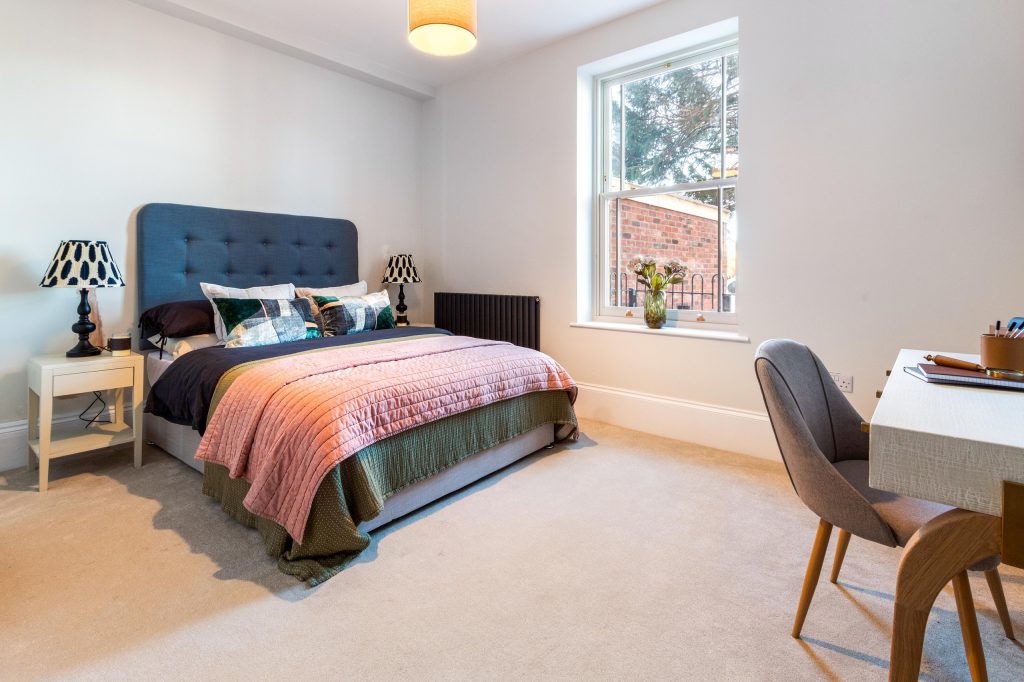This elegantly styled bedroom in Scartho, Lincolnshire, is designed to appeal to prospective buyers through modern comfort and subtle touches. A deep blue, button-tufted headboard adds...