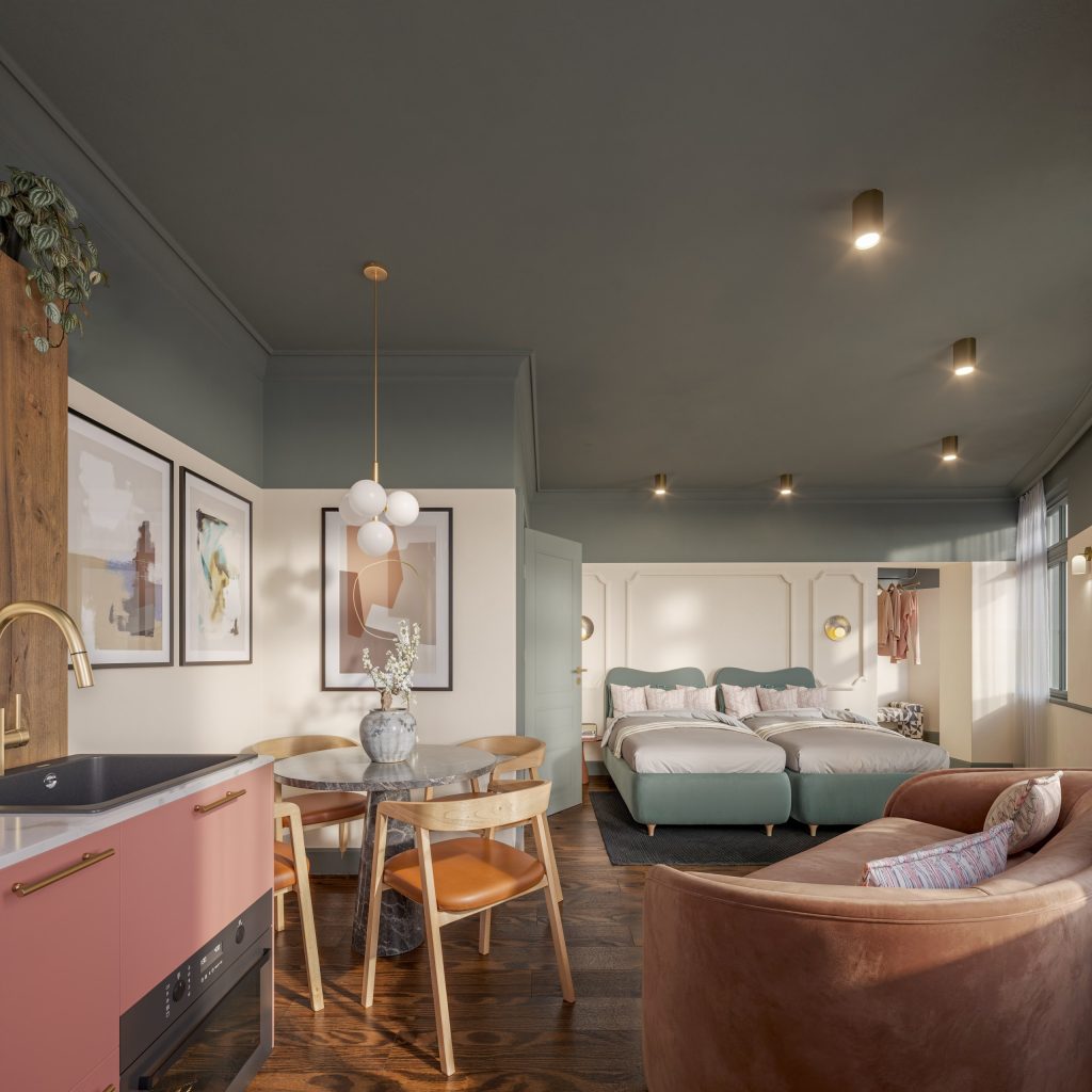Studio suite with a dining nook, a curved tan banquette and soft pink cabinetry beneath warm lighting.